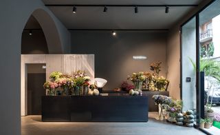 The entrance of the restaurant shows a black countertop covered with vases full of wildflowers.