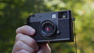 Fujifilm X half camera in the hand at golden hour