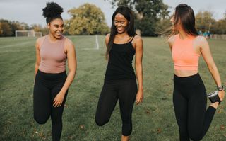 Gyms reopening: a group of women stretch pre working out together