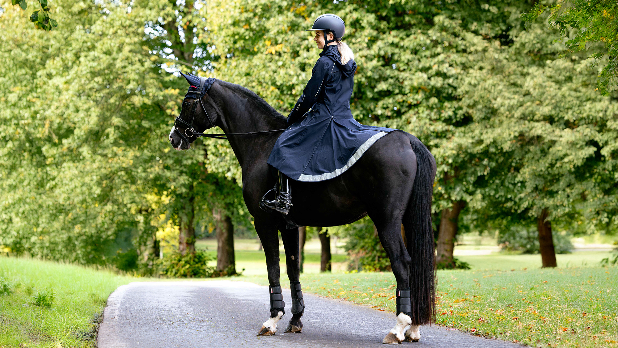 Rider on horse wearing a long waterproof riding coat 