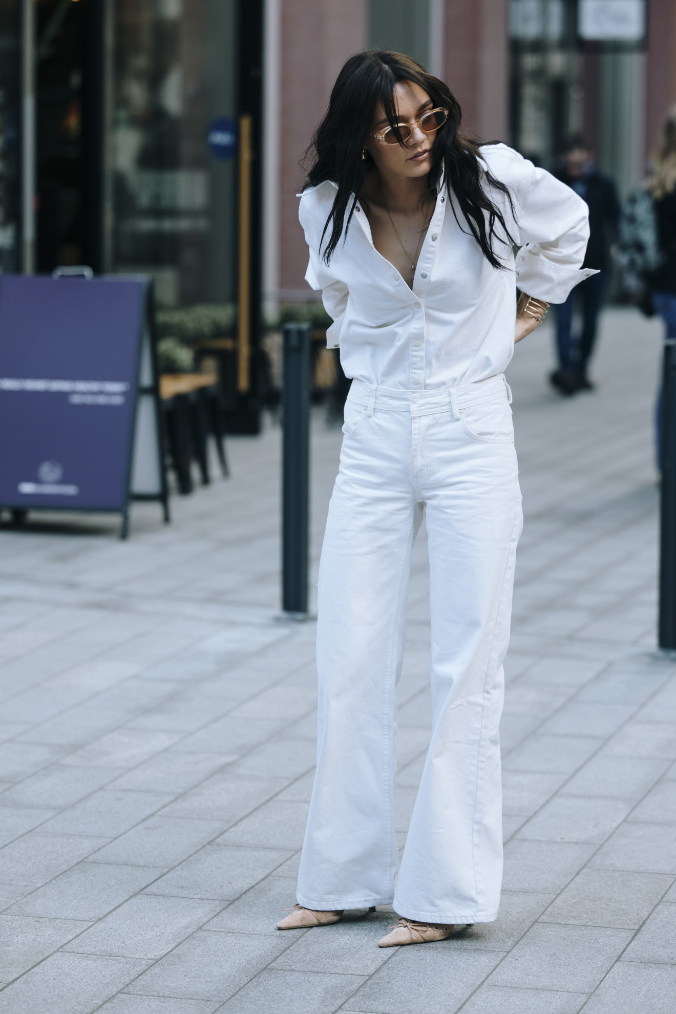 woman wearing a white button-down and white jeans and pointed-toe heels