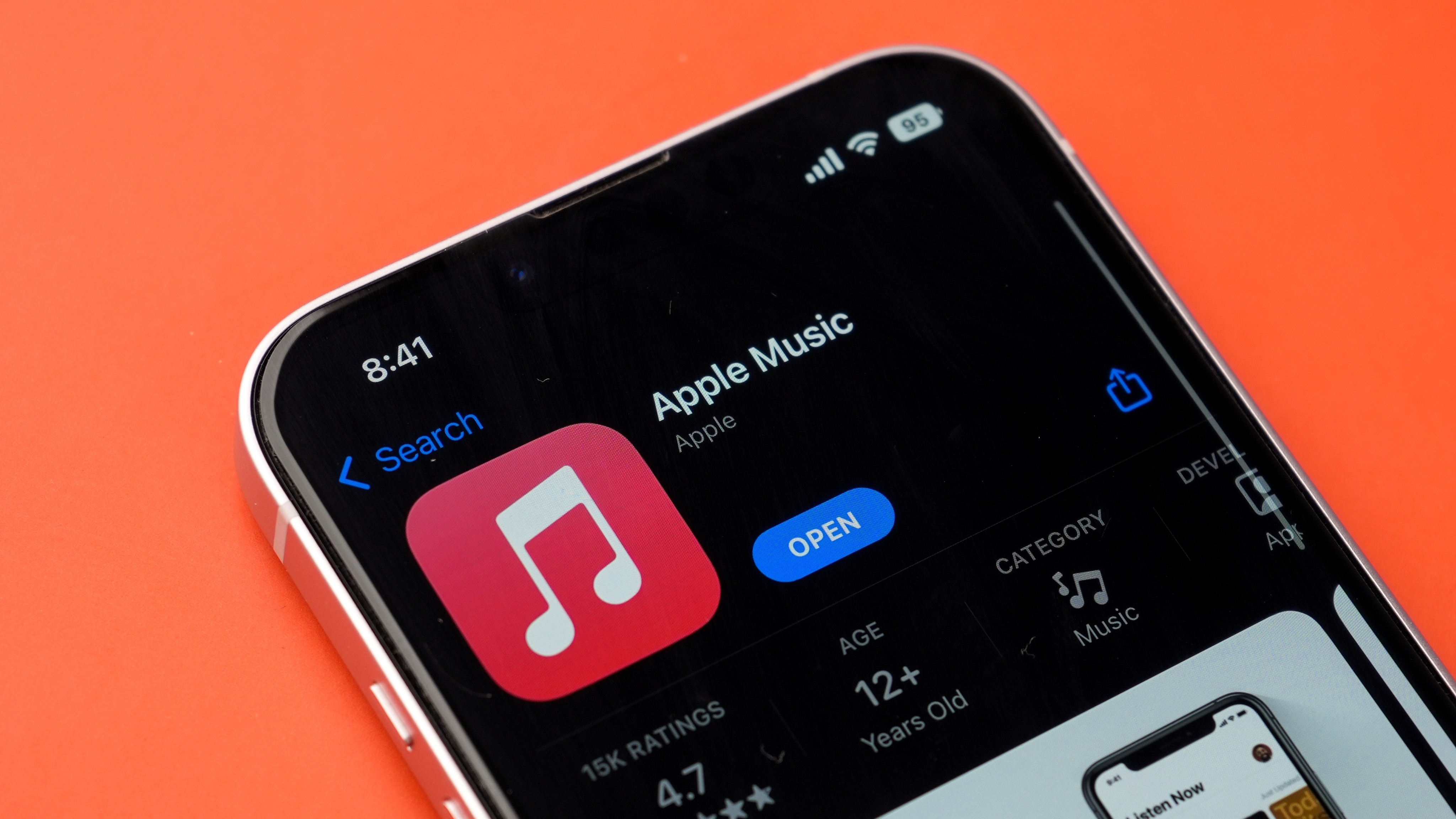 Apple Music in the iPhone app store on an orange background