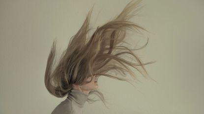 A woman with hair flying over her head