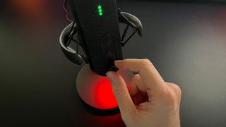 SteelSeries Alias review image showing the reviewer turning one of the microphone's dials.