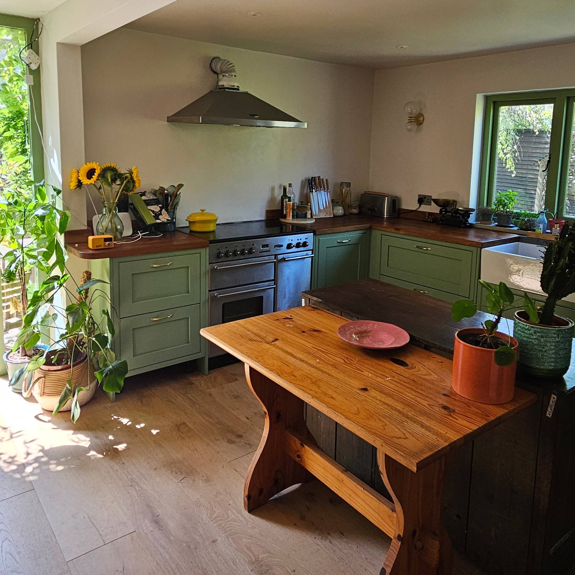 green kitchen with wooden table as island