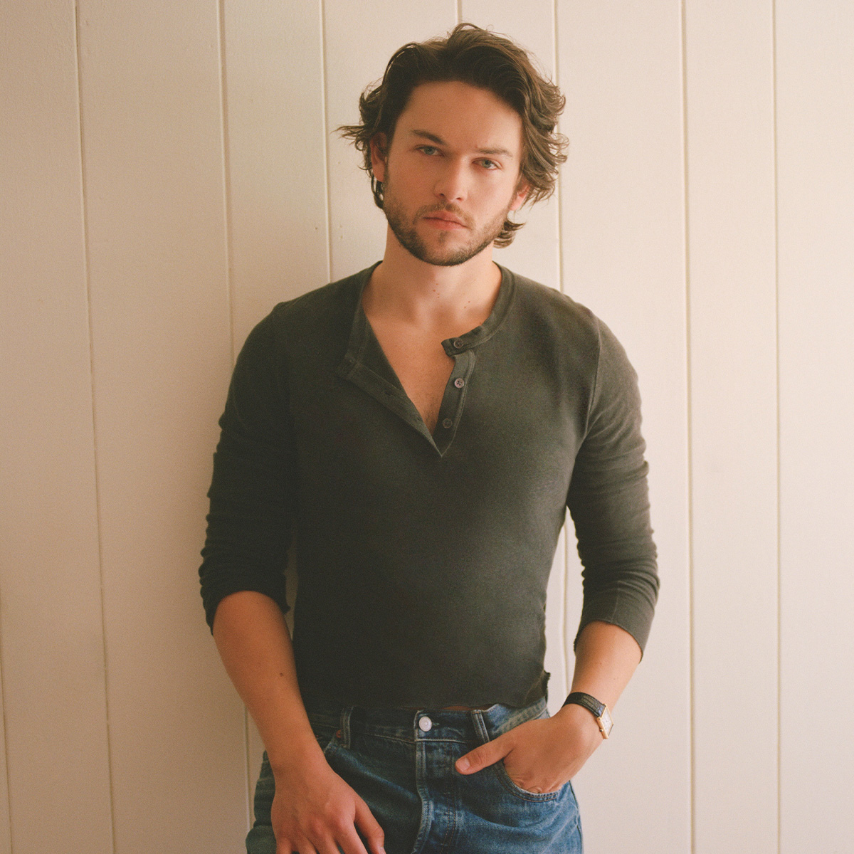 Actor Jack Martin shot by Max Montgomery for Who What Wear wearing an olive green three-quarter button-up shirt and jeans. 