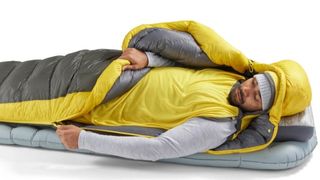 A man testing out the Sea to Summit Ether Light XR Insulated Air Sleeping Pad