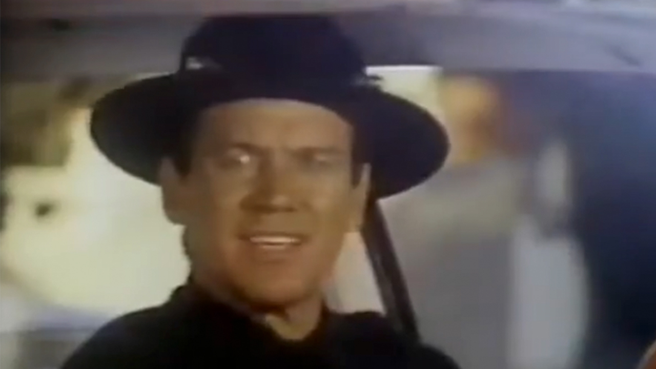 Sonny Shroyer wearing a hat in a car in Enos.