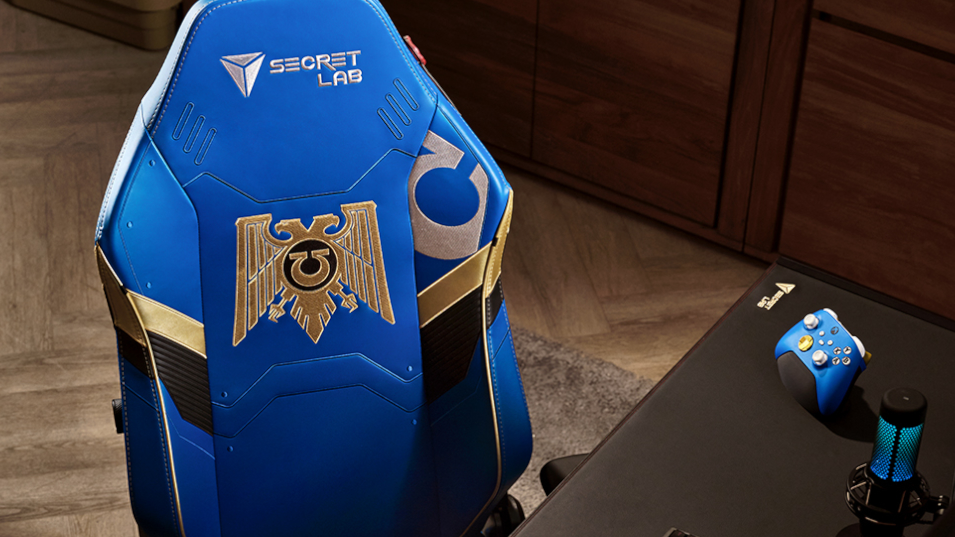 The Secretlab Warhammer 40,000 Ultramarines chair, seen tucked under a gaming desk with accessories nearby