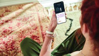 女人穿Fitbit豪华，检查Fitbit移动应用程序