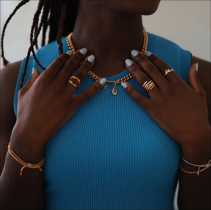 Guest wearing gold Ariane Ernst chain necklace with tear inspired diamond, silver and gold rings and gold Ariane Ernst bracelets on July 13, 2023 in Dusseldorf, Germany. 