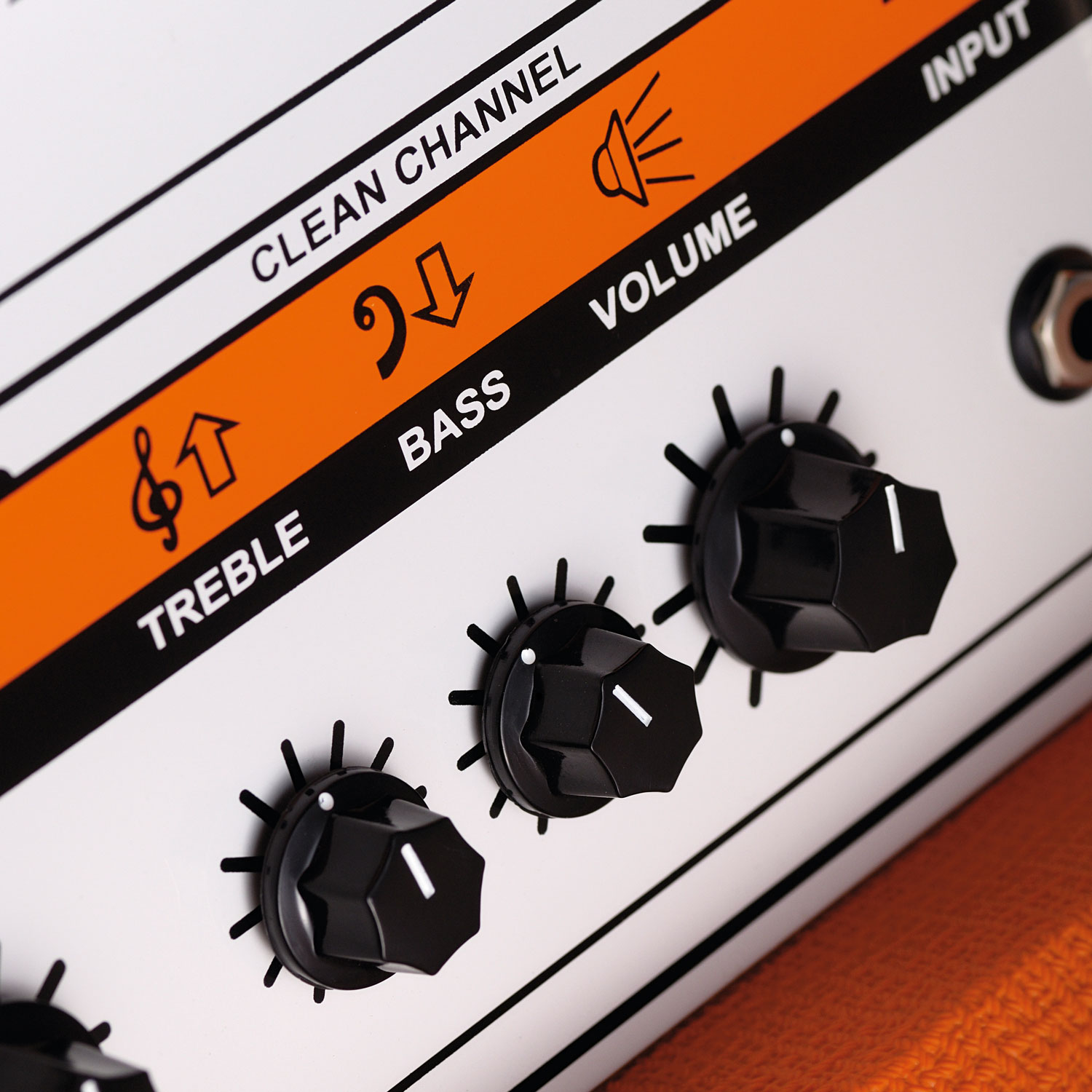 Close-up on an Orange amp treble, bass and volume control panel
