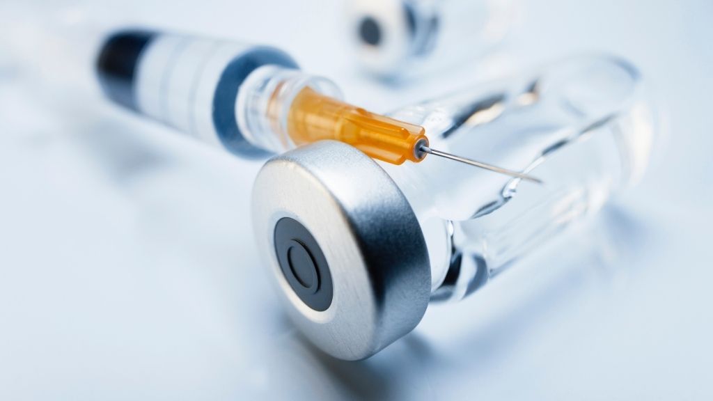 photo of a syringe placed on top of a vial of medication