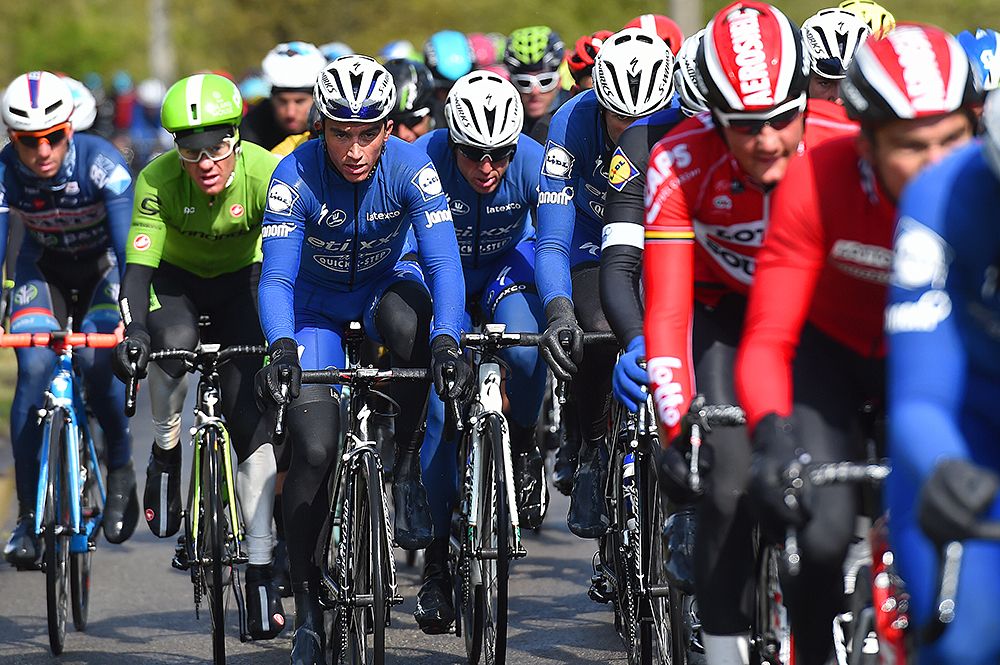 Etixx-QuickStep riders sit in the field at Liege-Bastogne-Liege