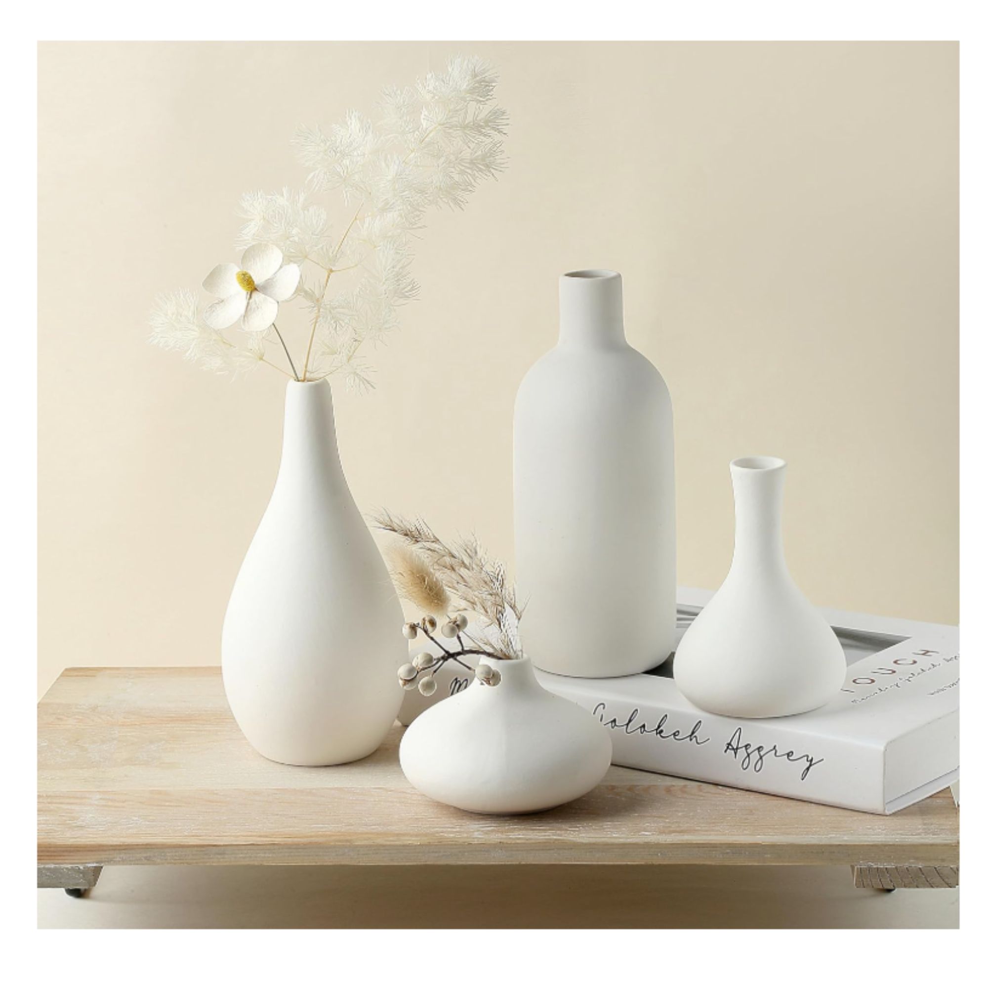 collection of four different white ceramic vases on a table