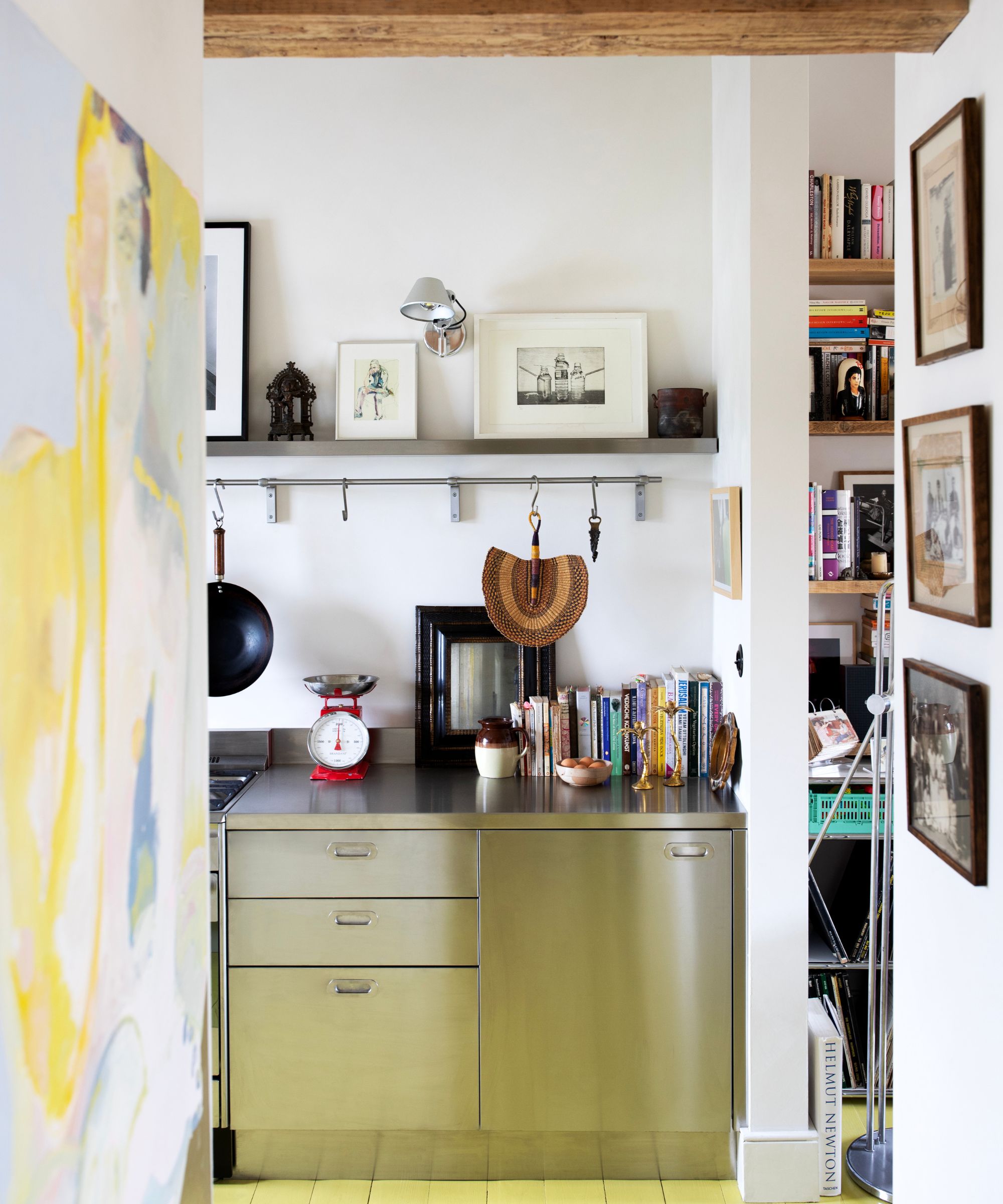 kitchen with stainless steel cabinets, a green floor, and white walls covered in art