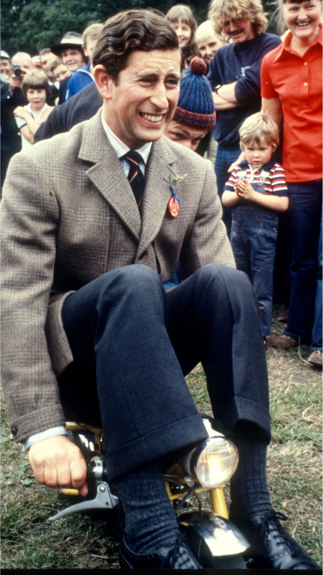 King Charles riding mini motorbike.
