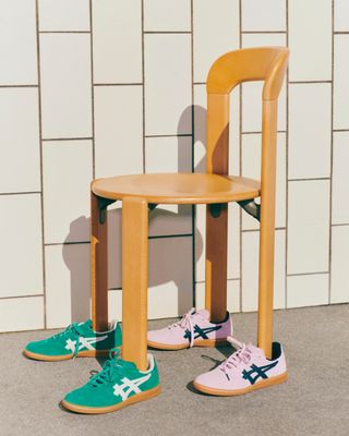 Asics and Hay sneakers in pink worn by a wooden chair