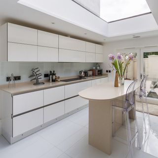 kitchen area with white wall and counter with plastic chair and tiles