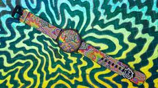 Brightly coloured watch on a patterned background