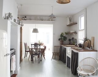 Boho style kitchen and dining area with white painted floorboards