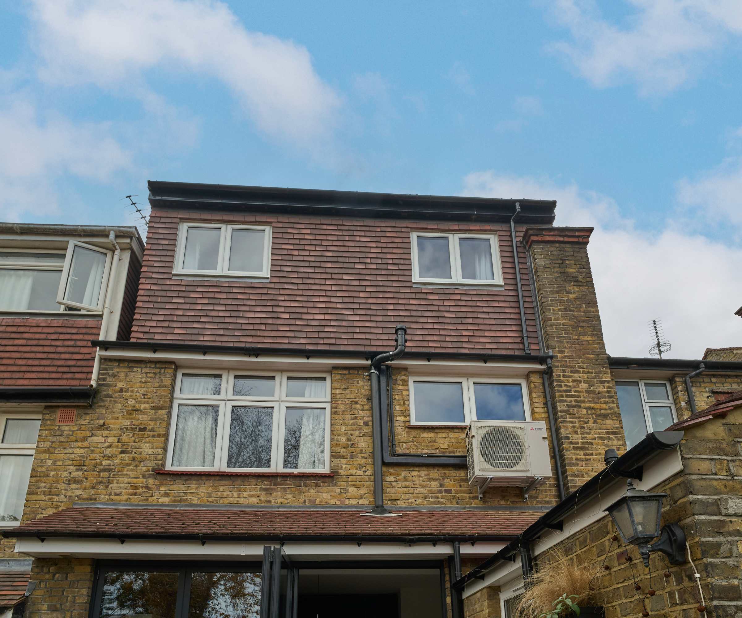 dormer loft conversion with a tile hung cladding system to match tiles on roof of small extension below
