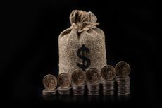 money bag with dollar sign behind rising stacks of coin