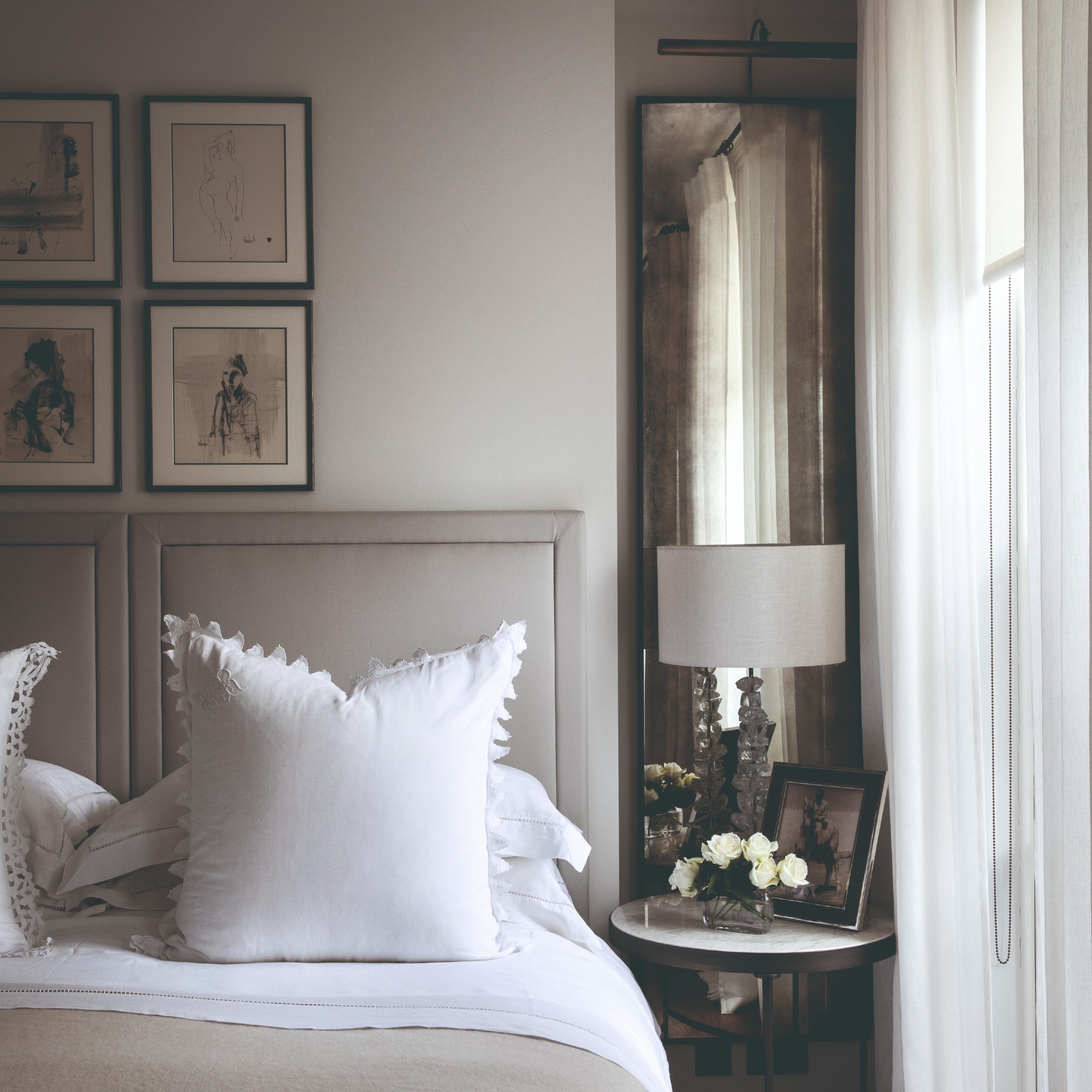 A hotel-style bedroom with a vintage-effect long mirror behind the bedside table