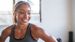 smiling athlete looking away while standing in gym - stock photo