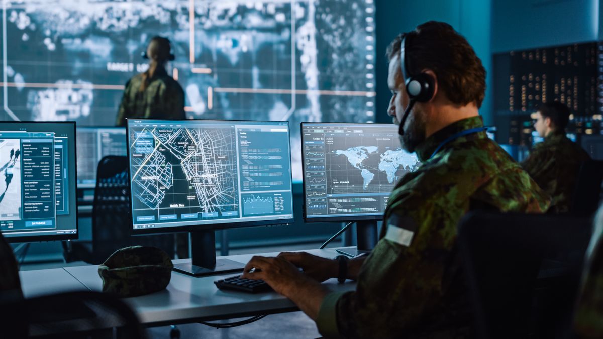 Military Surveillance Officer wearing camouflage working at a computer terminal