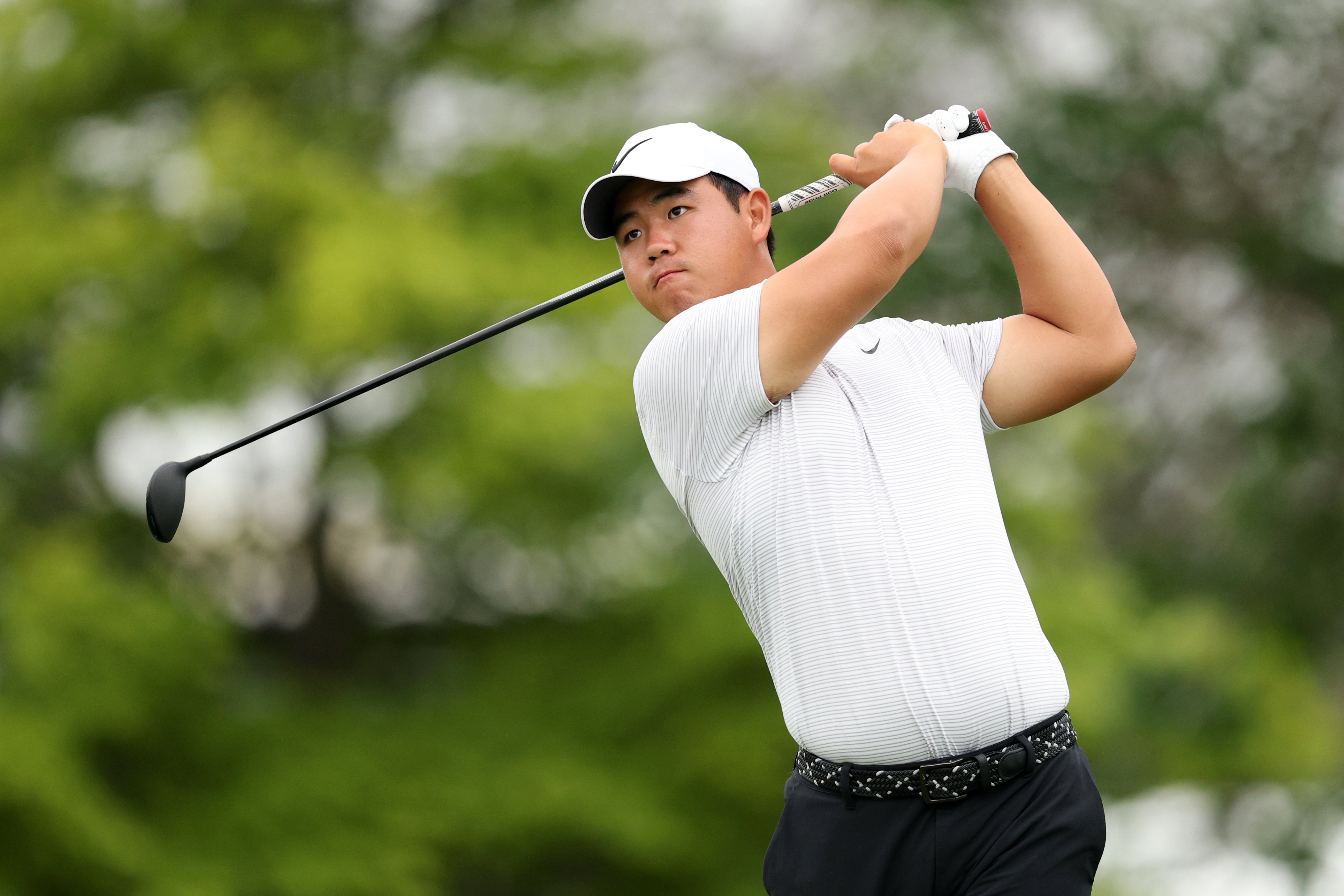 Tom Kim hits a fairway wood off the tee