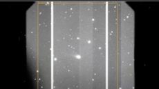 A gray scale image showing various white dots of stars and comets with a large smudge in the middle which is the interstellar comet 3I/ATLAS