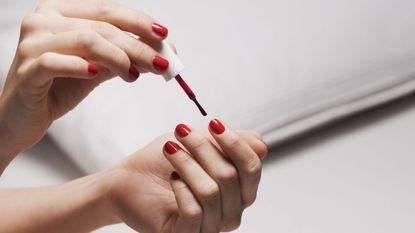 Red nail polish being applied