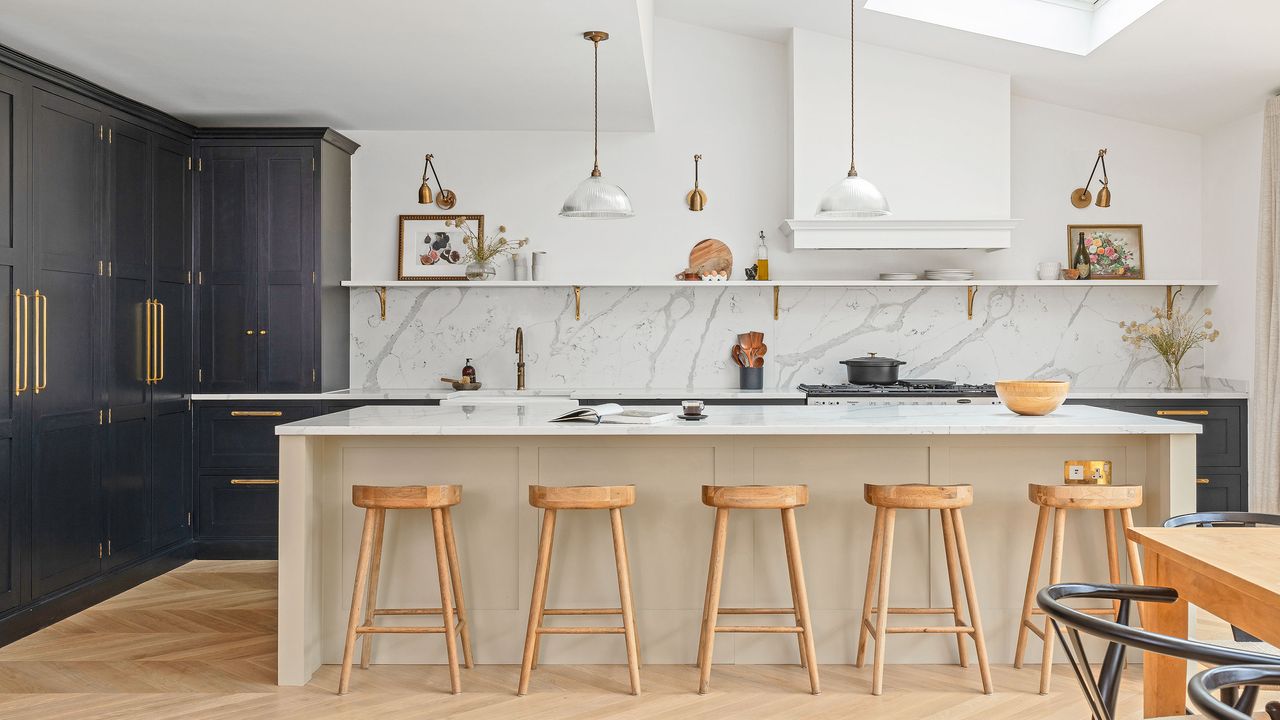 Large kitchen island with wooden bar stools and marble worktops