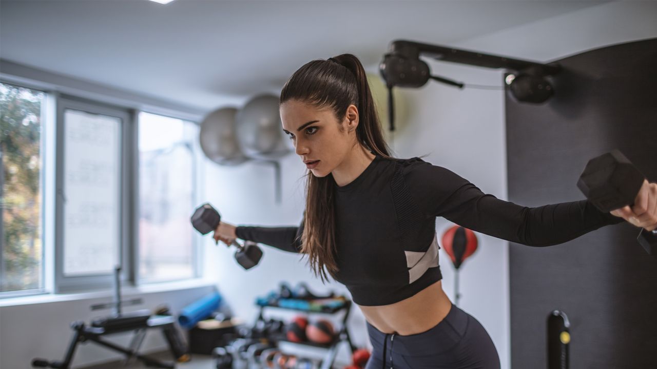 Chest and back workout: Image of woman lifting weight 