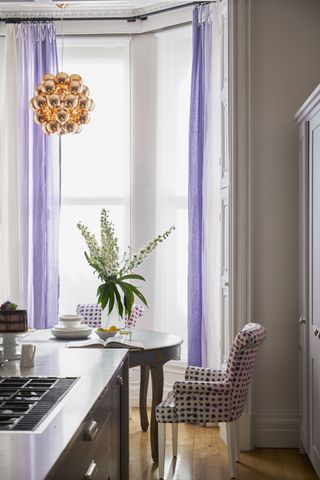 A kitchen with purple curtains