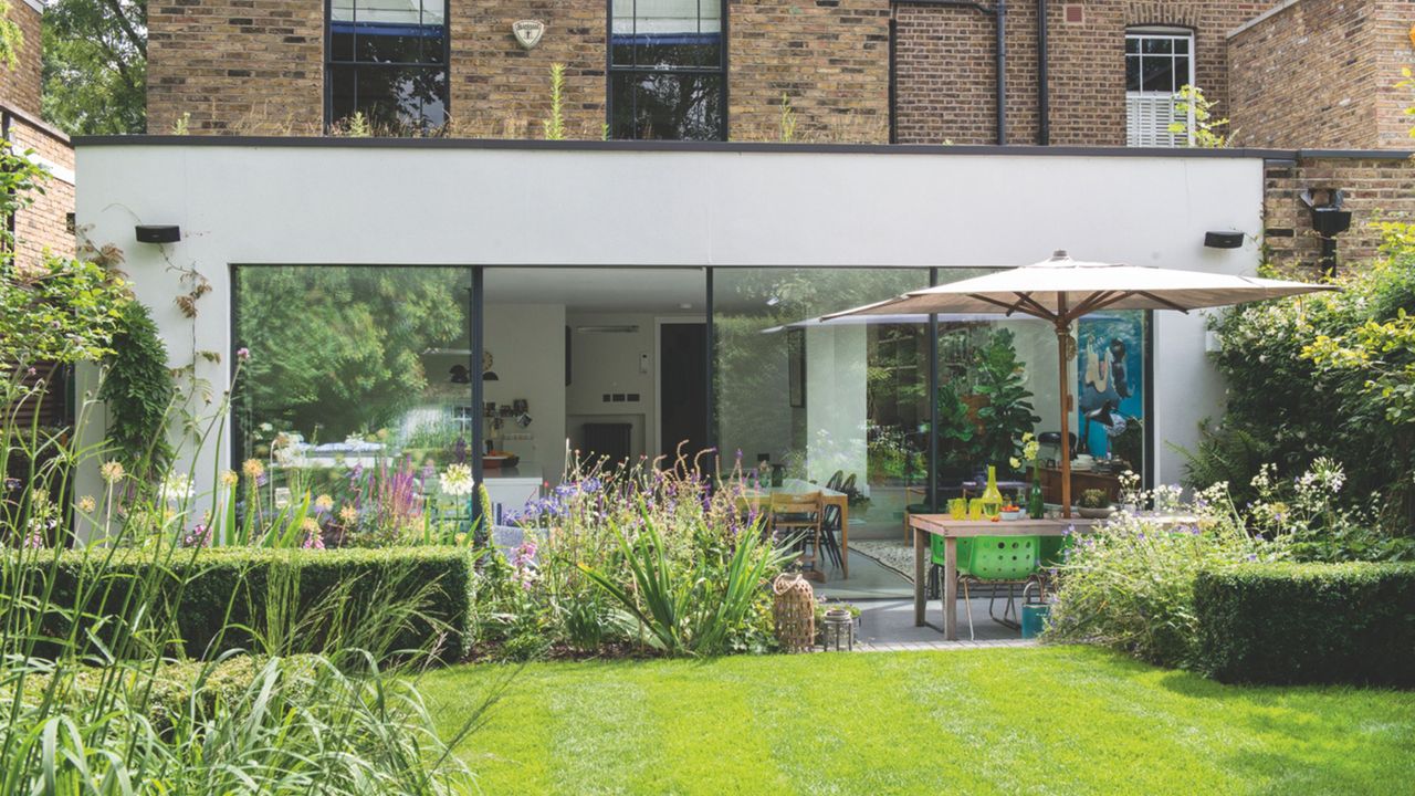 Rendered single storey extension with large glazed sliding doors looking out to the garden