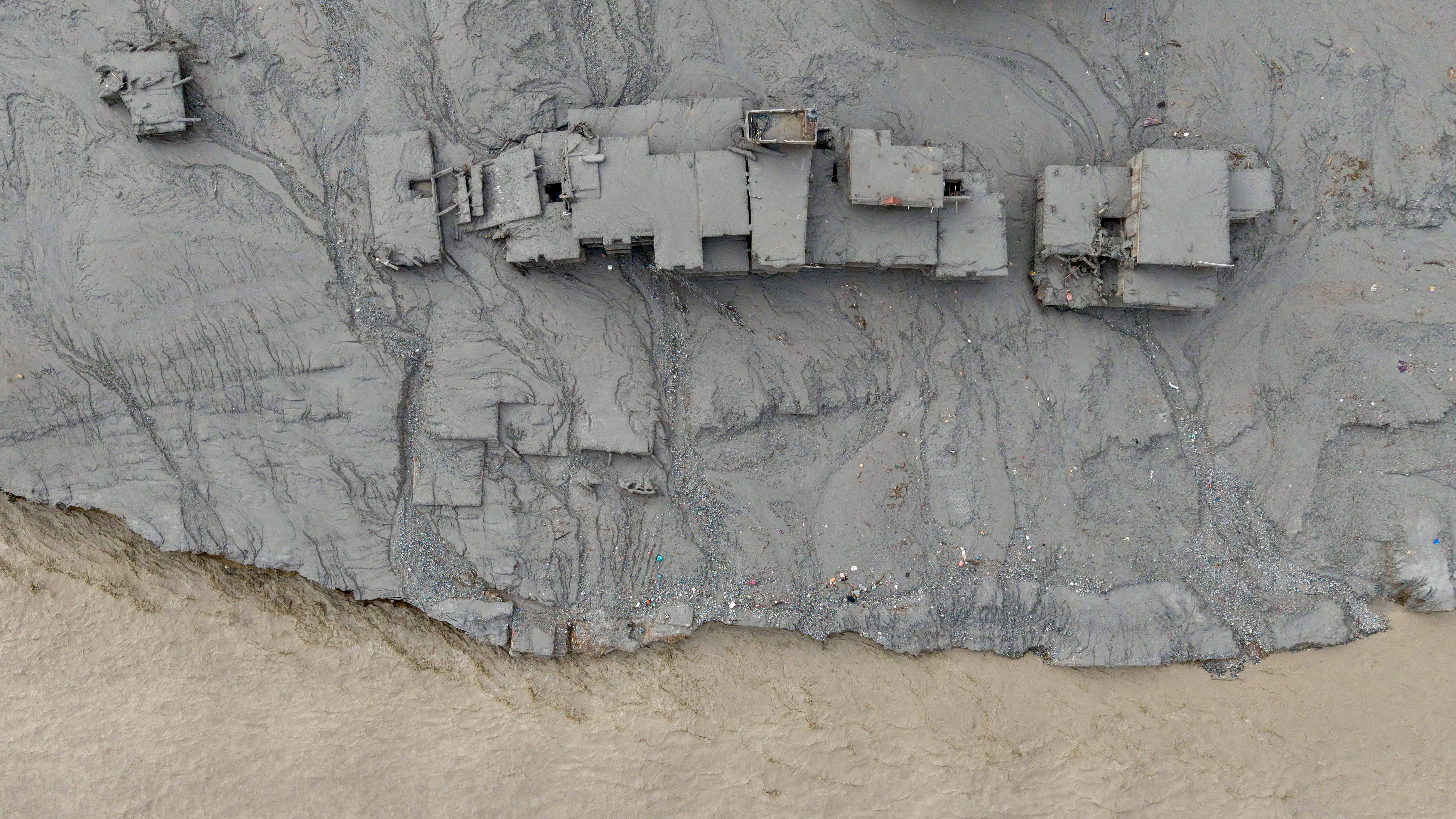 TOPSHOT - An aerial view shows houses lying deluged in sludge after flash floods at Devighat, Bidur Municipality in Nepal's Nuwakot district on August 27, 2026. Nepal's disaster agency said that 823 people remained out of contact on August 27, more than 24 hours after a deadly flood tore through the border region with Tibet. (Photo by Prabin RANABHAT / AFP via Getty Images)