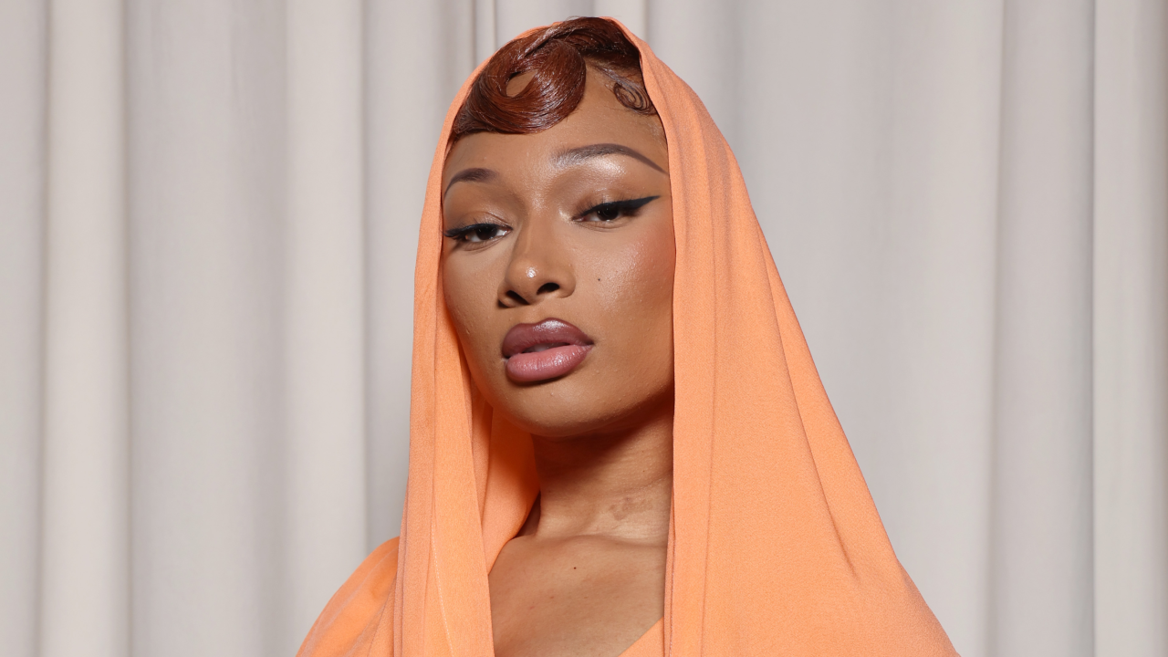 Megan Thee Stallion wearing a hooded dress and winged eyeliner.