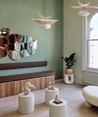 Retro living room painted in an earthy green color and decorated with curved furniture