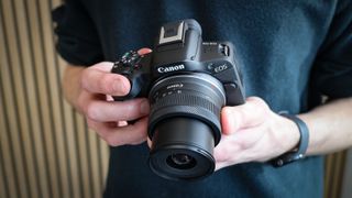 The Canon EOS R50 being held in a reviewer's hands