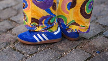 A guest wears royal blue suede sneakers from Adidas , outside Helmstedt, during the Copenhagen Fashion Week Autumn/Winter 2023 on February 02, 2023 in Copenhagen, Denmark