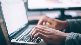 Person typing on computer.