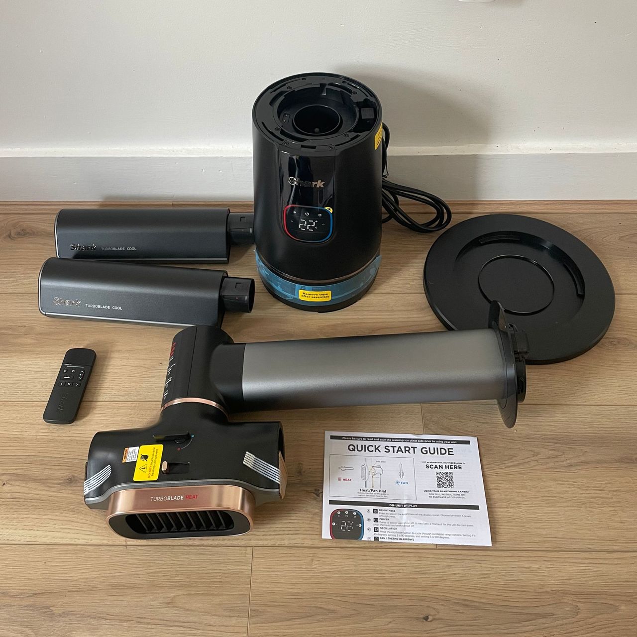 Components of the Shark TurboBlade Cool + Heat TH200UK laying on wood-effect flooring