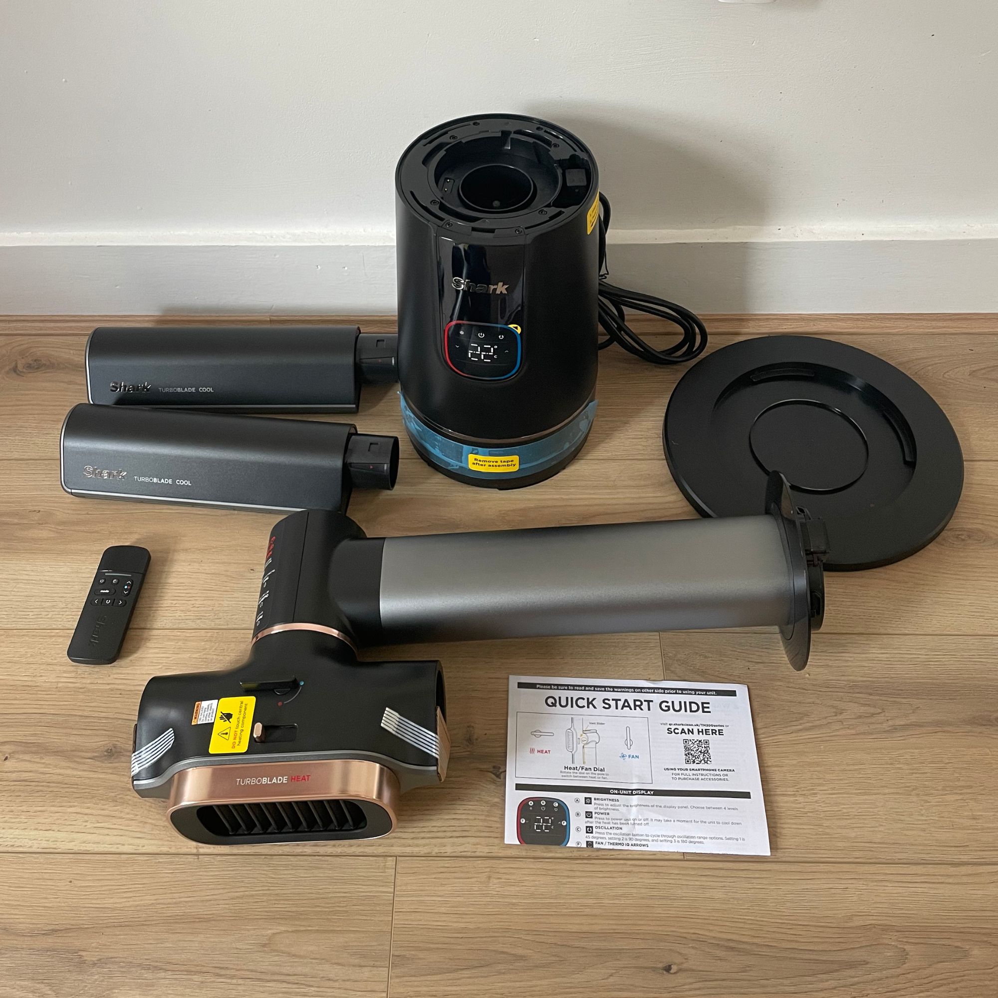 Components of the Shark TurboBlade Cool + Heat TH200UK laying on wood-effect flooring