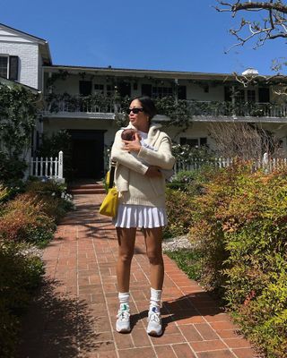 @aimeesong mengenakan New Balance dengan rok tenis putih