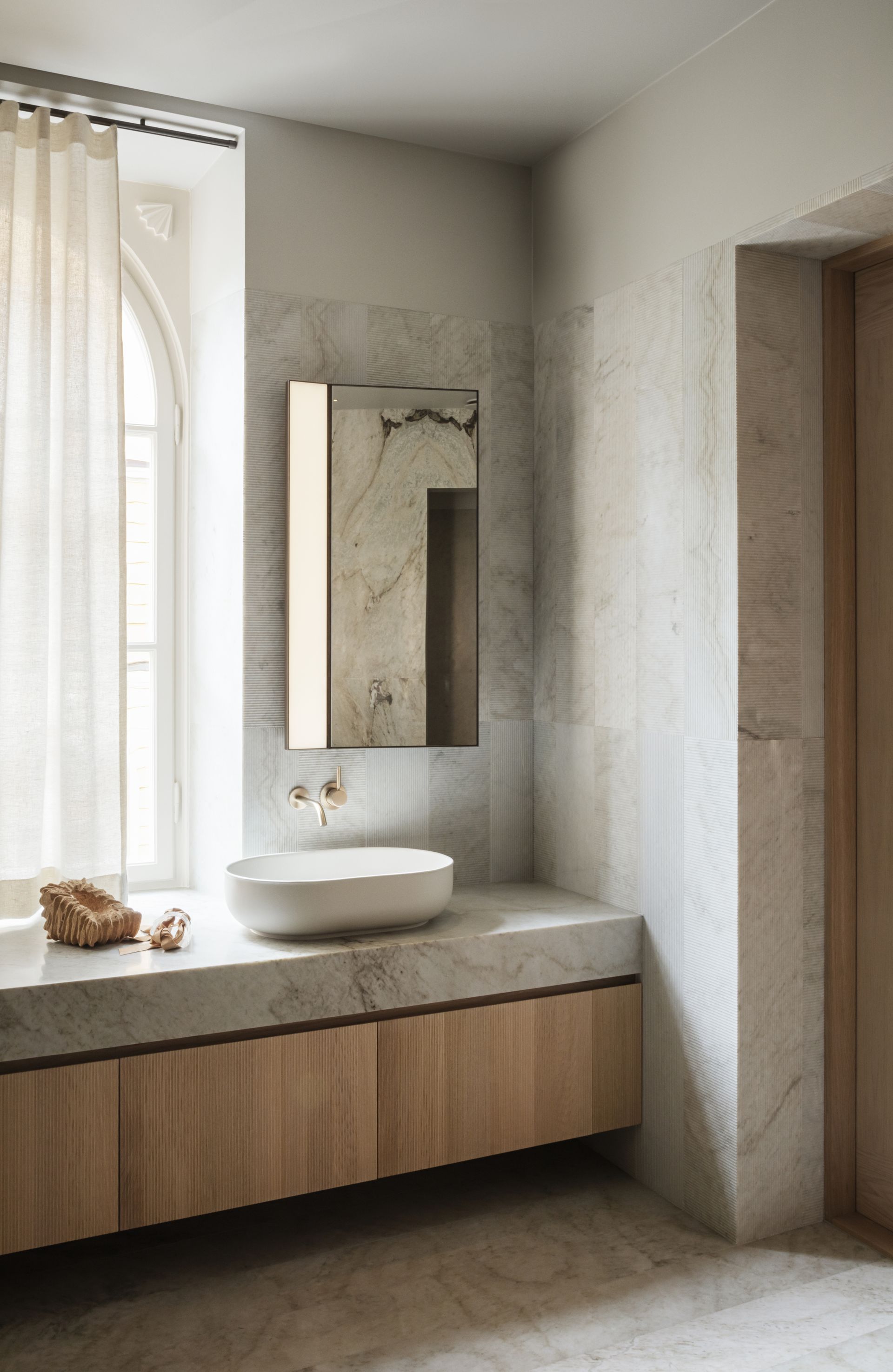 A bathroom with curtains on the vanity window