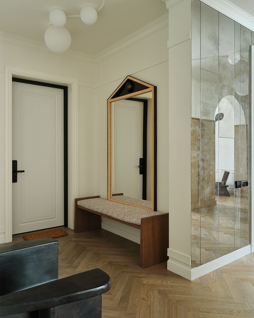 An entry area with a bench seat and a hanging mirror
