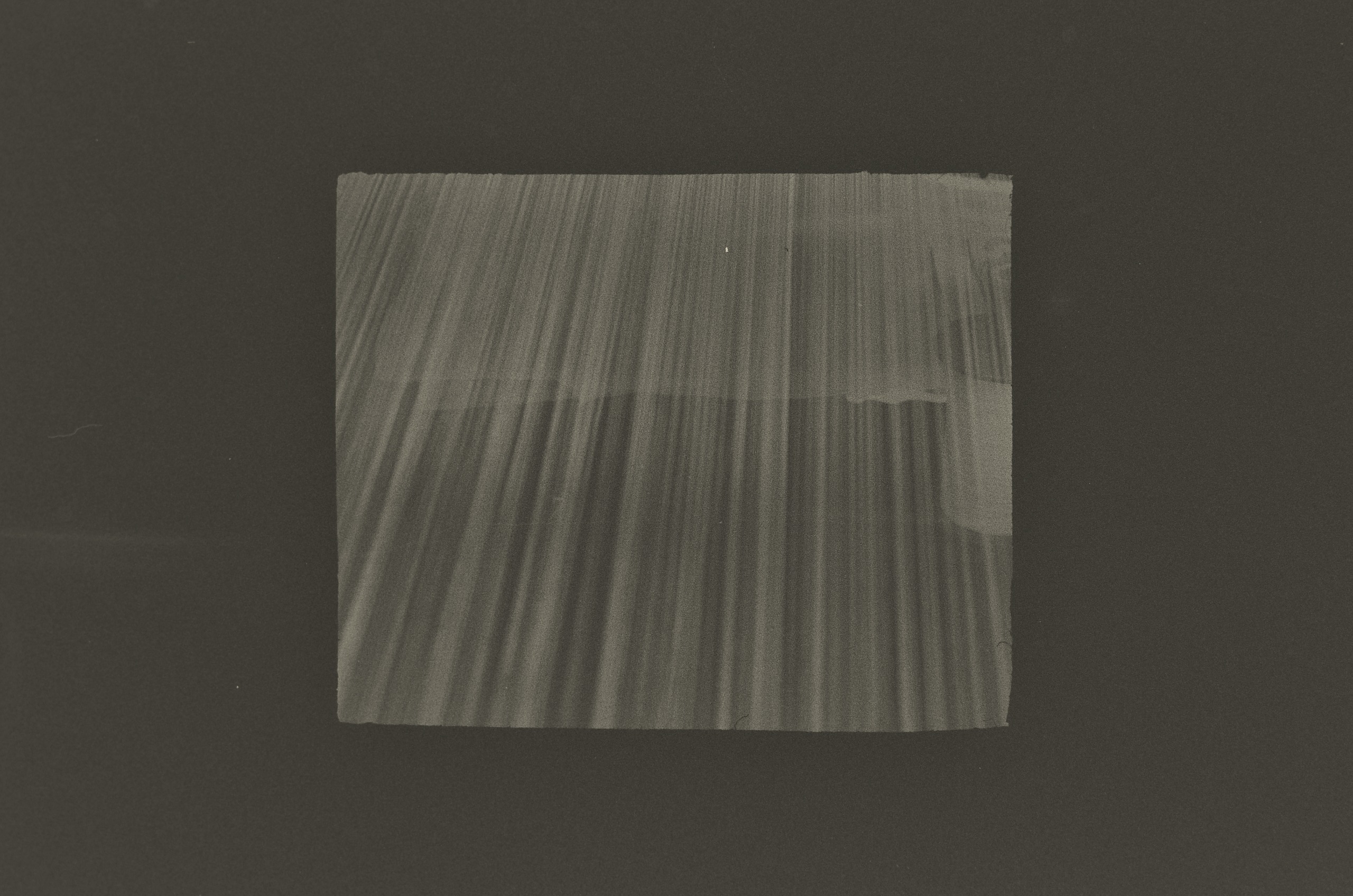 A black-and-white print by Jing Huang of fine silk threads fanning out across a loom, forming a pattern of soft pale and dark lines.
