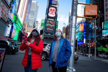 People wear face masks as they visit Times Square in New York on December 10, 2020.